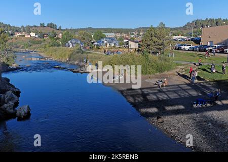 Am Ufer des San Juan River in der Innenstadt von Pagosa Springs, Colorado, treffen sich Menschen vor dem Start der Colorfest Heißluftballonfahrt 2022. Stockfoto