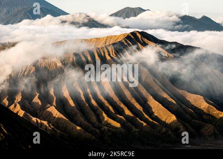 Mount Bromo, Berg im Tengger Semeru Nationalpark, Java bei Sonnenaufgang mit Meereswolken, die schwarze Schatten bilden, Indonesien Stockfoto