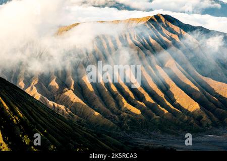 Mount Bromo, Berg im Tengger Semeru Nationalpark, Java bei Sonnenaufgang mit Meereswolken, die schwarze Schatten bilden, Indonesien Stockfoto