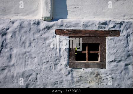 Altes Holzfenster an der weißen Wand des Hauses Stockfoto