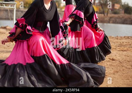 Gipsy tanzt in hellen Kleidern. Mädchen tanzen auf der Straße spanischen Tanz. In leuchtender Qualität. Tanzbewegungen. Stockfoto