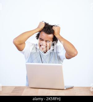 Frustriert seine Haare herausziehen. Frustrierter Geschäftsmann sitzt an seinem Laptop. Stockfoto