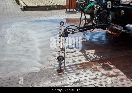 Eine spezielle Maschine wäscht Stadtwege und Straßen mit Wasser Stockfoto