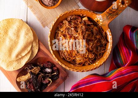 Tinga de Res. Typisch mexikanisches Gericht, das hauptsächlich mit geschreddertem Rindfleisch, Zwiebeln und getrockneten Chilischoten zubereitet wird. Es ist üblich, es auf Maistortilla Tostadas zu servieren Stockfoto