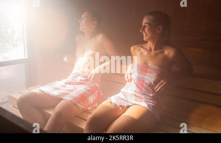 Glückliches Paar, das gemeinsam die Sauna im Spa genießt. Dampfbad im Saunraum, Spa- und Wellnesskonzept, Entspannung in der heißen finnischen Sauna. Stockfoto