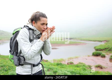 Gestresster Wanderer, der kalt wird, läuft in den Bergen ein nebliger Tag Stockfoto