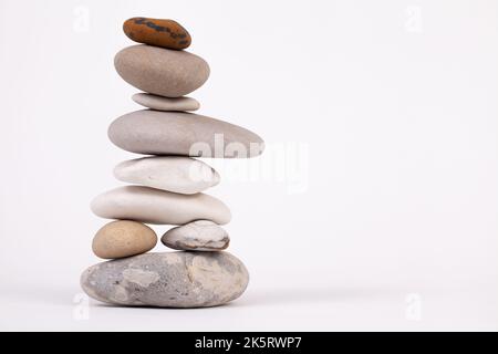 Säule aus Buchensteinchen isoliert auf weißem Studiohintergrund. Zen-Entspannungskonzept Stockfoto