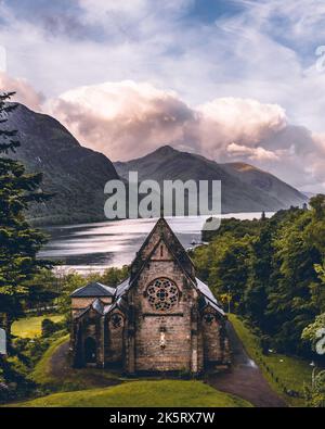 Eine vertikale Luftaufnahme der Saint Mary & Saint Finnan Church am Seeufer in Glenfinnan, Schottland Stockfoto