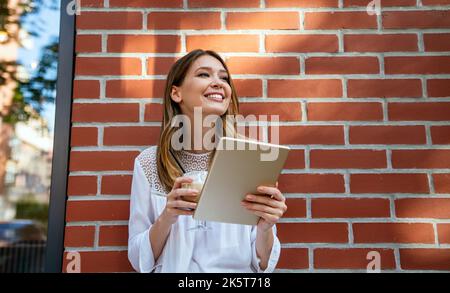 Schöne junge Frau im Café, mit digitalen Tablet und Kaffee trinken lächelnd Stockfoto