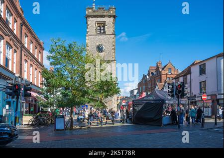 Am Samstagmarkttag sind Leute unterwegs, einige machen eine Pause unter dem Uhrenturm. St Albans, Hertfordshire, England, Großbritannien Stockfoto