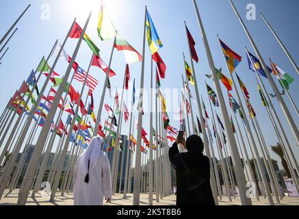 2022-10-05 10:48:49 Foto aufgenommen am 05. Oktober 2022. Die Menschen fotografieren Flaggen, die vom Staat Katar akkreditierte diplomatische Missionen repräsentieren, während sie vor dem FIFA-Fußballwettbewerb 2022 an der neuen Flag Plaza an der Doha corniche in Doha - Katar fliegen. niederlande aus - belgien aus Stockfoto