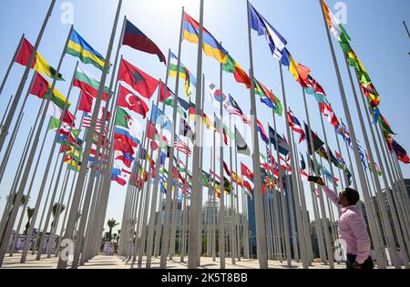 2022-10-05 10:31:53 Foto aufgenommen am 05. Oktober 2022. Ein Mann macht ein Foto von Flaggen, die Nationen mit diplomatischen Missionen repräsentieren, die vom Staat Katar akkreditiert sind, während sie vor dem FIFA-Fußballwettbewerb 2022 an der neuen Flag Plaza an der Doha corniche in Doha - Katar fliegen Stockfoto