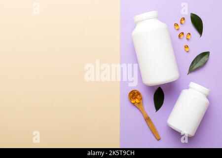 Omega-3 Kapseln liegen in einer weißen Flasche auf einem Tisch mit grünem Blatthintergrund. Fischöltabletten. Biologisch aktive Zusatzstoffe. omega 6, Omega 9, Vitam Stockfoto