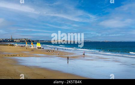 Blick auf den Strand du Sillon mit Menschen, die Freizeit- und Wasseraktivitäten genießen, mit der mittelalterlichen Stadt Saint Malo im Hintergrund. Stockfoto