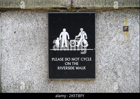 LONDON - 21. Mai 2022: Bitte nicht auf dem Riverside Walk radeln - Schild an der Wand Stockfoto