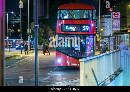 LONDON - 21. Mai 2022: Passagier zahlt für die Busfahrt mit dem roten Doppeldeckerbus nachts vor der Waterloo Station Stockfoto