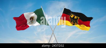 Zwei gekreuzte Flaggen, Deutschland und mexiko, winken im Wind bei bewölktem Himmel. Konzept der Beziehung, des Dialogs, des Reisens zwischen zwei Ländern. 3D Abbildung Stockfoto
