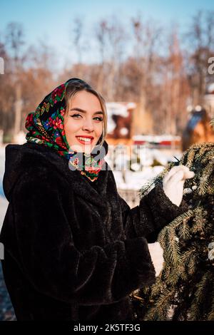 Schönes Mädchen in einem ukrainischen nationalen Schal im Winter auf der Straße Stockfoto