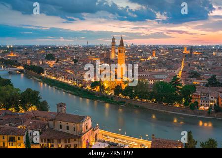 Verona Italien, Blick in der Abenddämmerung auf das historische Stadtzentrum von Verona mit der Etsch und der beleuchteten Sant'Anastasia Kirche, Verona, Italien Stockfoto