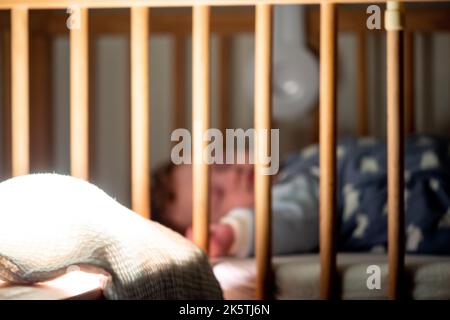 Schlafen Baby in eigenem Kinderbett mit dunkles Licht Stockfoto