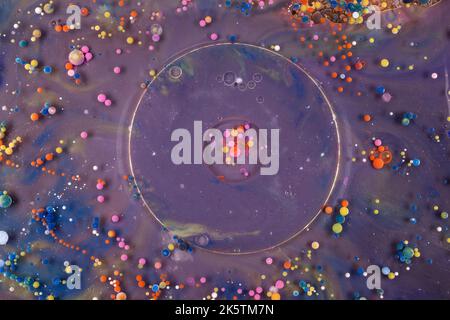Acrylfarbe Kugeln abstrakte Textur. Leuchtende Farben fließendes Tapetendesign. Violette, blaue, rosa und gelbe Flüssigkeiten mischen sich. Stockfoto
