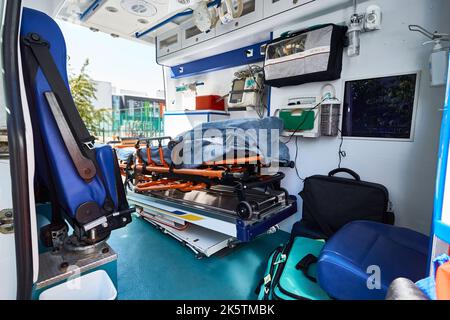 Ambulanzraum mit Liege, Defibrillator und anderen medizinischen Geräten und Hilfsgütern an Bord. EMS Stockfoto