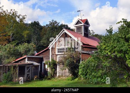 Lower Bartonsville, Vermont, USA. Ein rustikaler Schuppen/Lagerscheune komplett mit einer schiefen Wetterfahne auf einer Dachkuppel. Stockfoto