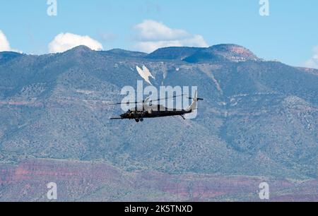 Ein einziger Hubschrauber der Army fliegt mit einem Berg im Hintergrund Stockfoto