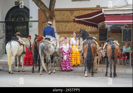 Spanische Reiter in einer Bar, mit jungen Frauen in traditioneller spanischer Kleidung, während der jährlichen Messe, Feria. Fuengirola, Andalusien. Stockfoto