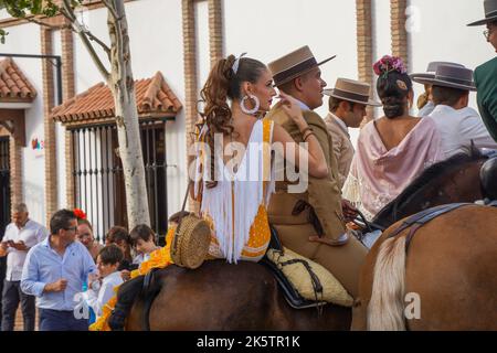 Spanischer Reiter in einer Bar, mit einer jungen Frau auf dem Rücken, während der jährlichen Messe Feria. Fuengirola, Andalusien. Stockfoto