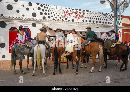 Spanische Reiter an einer Bar, mit einer jungen Frau auf dem Rücken, während der jährlichen Messe, Feria. Fuengirola, Andalusien. Stockfoto