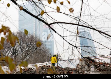 Mailand, Italien - 16. Dezember 2019: Ein Arbeiter auf einer Baustelle mit im Hintergrund skyscaprers des Tre Torri Komplexes, im City Life District Stockfoto