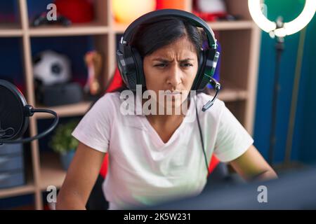 Junge schöne hispanische Frau streamer spielen Videospiel mit Computer auf der Straße Stockfoto