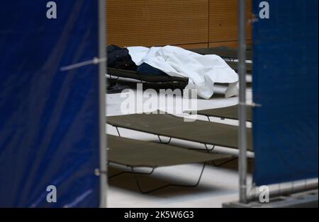 Dresden, Deutschland. 10. Oktober 2022. Ein Flüchtling schläft nach der Registrierung auf einem Kinderbett im Ankunftsbereich für Flüchtlinge am Hauptbahnhof. Kredit: Robert Michael/dpa/Alamy Live Nachrichten Stockfoto