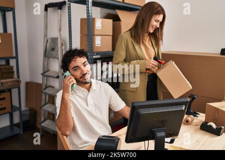 Im Büro sprechen Männer und Frauen mit dem Smartphone-Scan-Paket Stockfoto