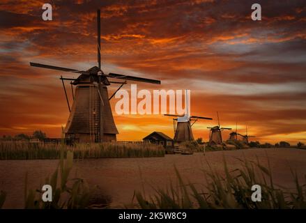 Alte Windmühlen in Kinderdijk bei dramatischem Sonnenuntergang in den Niederlanden Stockfoto