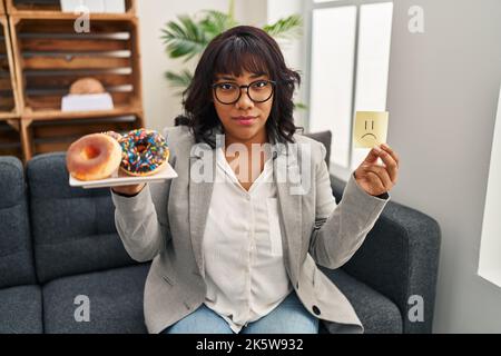 Hispanische Therapeutin Frau, die an Essstörungen arbeitet, entspannt mit ernstem Gesichtsausdruck. Einfach und natürlich auf die Kamera schauen. Stockfoto