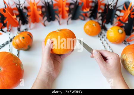 Halloween am 31. Oktober. Der Schritt-für-Schritt-Prozess des Schnitzens eines Kürbisses. Blick von oben Stockfoto