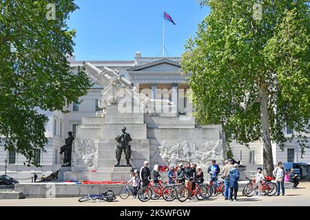 Tourguide bei geführter Führung Gruppe von Frauen und Männern, die sich Fahrräder ausgeliehen haben, um das Royal Artillery Memorial Hyde Park Corner London England zu besichtigen Stockfoto