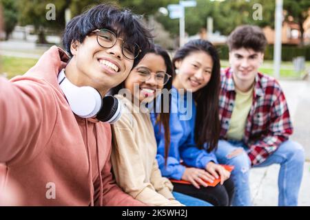 Internationale Gruppe junger Studenten, die Selfie mit Telefon auf dem College-Campus machen Stockfoto