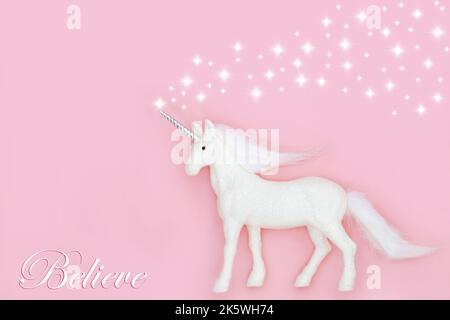 Weihnachten mythische magische Einhorn mit glauben in magische Thema auf rosa Hintergrund mit weißen Sternen. Märchenabstrakt für Weihnachten und Neujahr Stockfoto