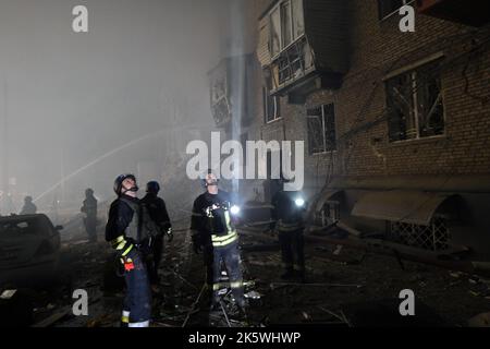 Non Exclusive: SAPORISCHSCHSCHJA, UKRAINE - 10. OKTOBER 2022 - Retter löschen das Feuer, das durch einen russischen Raketenangriff auf ein Wohngebäude, Z, verursacht wurde Stockfoto