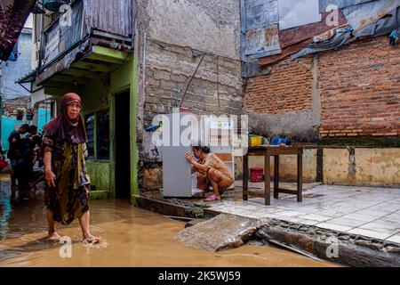 Jakarta, Indonesien. 10. Oktober 2022. Die Bewohner putzen Haushaltsgeräte während der Zeit danach. Durch das Überlaufen des Ciliwung River wurden 68 Gebiete in Jakarta von Überschwemmungen heimgesucht. Kredit: SOPA Images Limited/Alamy Live Nachrichten Stockfoto