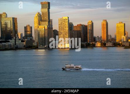 Am frühen Morgen des Herbstes fuhr eine Fähre den Hudson River entlang, mit der Pendler aus New Jersey nach Manhattan kamen. Stockfoto