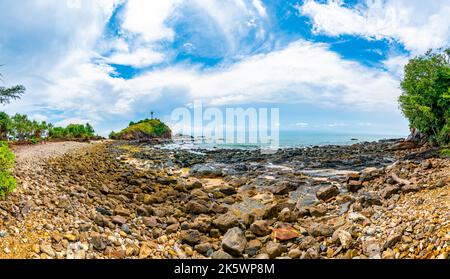 Leuchtturm auf dem Felsen im Mu Ko Lanta Nationalpark, Thailand. Blick vom Strand mit Steinen. Sommerwetter, blauer Himmel mit Wolken. Stockfoto