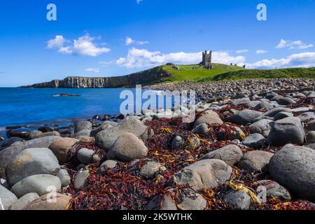 Dunstanburgh Castle aus Embleton Bay, Northumberland, England. Stockfoto