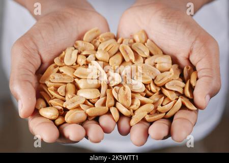 Männer, die viele Erdnüsse in der Nähe halten Stockfoto