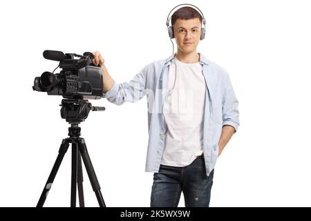 Junger Kameramann posiert mit Kamera auf einem isolierten Stand auf weißem Hintergrund Stockfoto