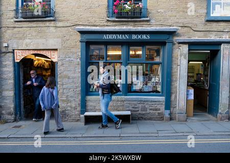 Menschen, die im Herbst am National Bookshop Day vor dem Addyman-Buchladen in der Buchstadt Hay-on-Wye Powys Wales UK KATHY DEWITT auf der Straße spazieren Stockfoto