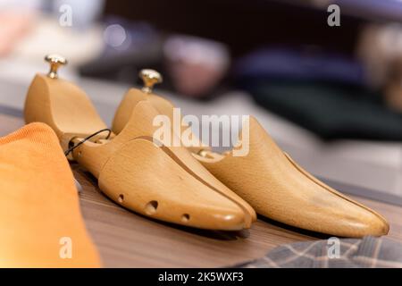 Neue Schuhformen oder Formen aus Holz für die Herstellung von Schuhen auf einem Regal in der Herrenschuhboutique. Stockfoto